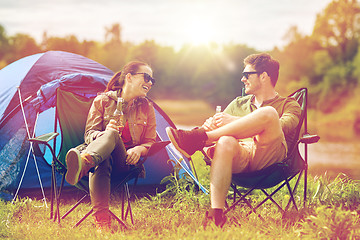 Image showing happy couple drinking beer at campsite tent