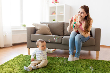 Image showing mother with soap bubbles playing with baby at home