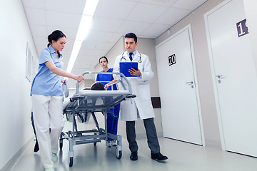 Image showing medics with woman on hospital gurney at emergency