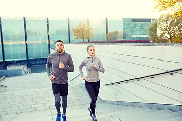 Image showing happy couple running upstairs on city stairs