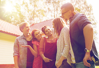 Image showing happy teenage friends talking at summer garden