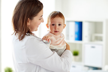 Image showing happy doctor or pediatrician with baby at clinic