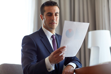 Image showing businessman with papers working at hotel room