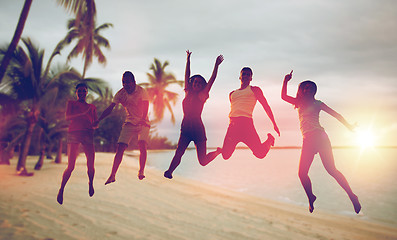 Image showing happy friends dancing and jumping on beach