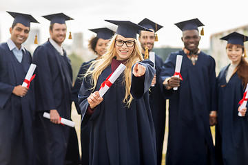 Image showing happy student with diploma pointing finger at you