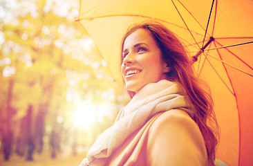 Image showing happy woman with umbrella walking in autumn park