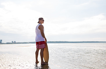 Image showing happy young man with skimboard on summer beach