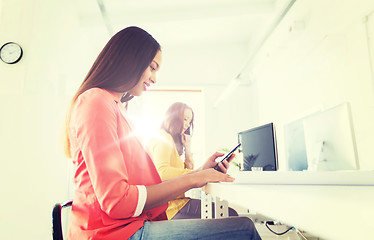 Image showing businesswoman texting on smartphone at office