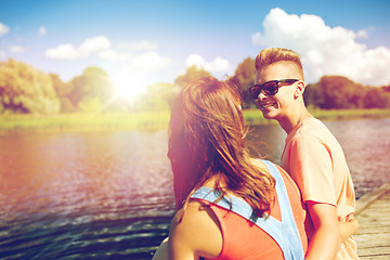 Image showing happy teenage couple sitting on river berth