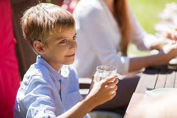Image showing happy boy with glass of water at festive dinner