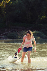 Image showing Woman playing with dog in water