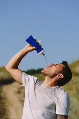 Image showing Thirsty person drinking water on nature