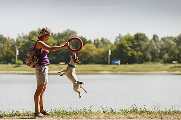 Image showing Woman playing with dog on nature