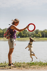 Image showing Woman playing with dog on nature