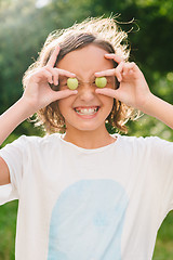 Image showing Cheerful girl playing with plums