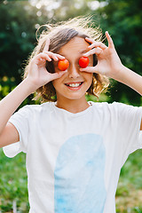 Image showing Cheerful girl playing with plums