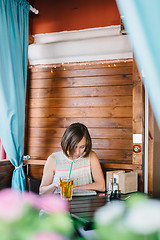 Image showing Girl in cafe with drink and tablet