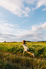 Image showing Cheerful girl running with kite