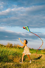 Image showing Cheerful girl running with kite