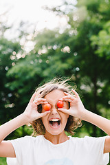 Image showing Cheerful girl playing with plums