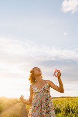 Image showing Girl holding kite and running in field