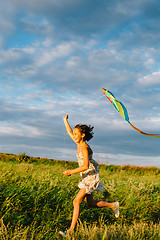Image showing Cheerful girl running with kite