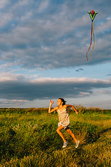 Image showing Cheerful girl running with kite