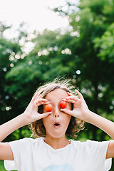 Image showing Cheerful girl playing with plums