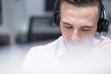 Image showing male call centre operator doing his job