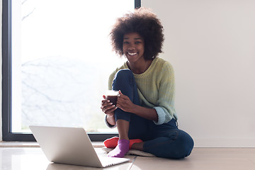 Image showing black woman in the living room on the floor