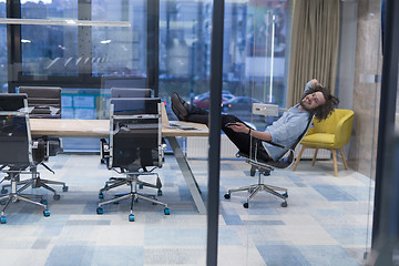 Image showing young businessman relaxing at the desk