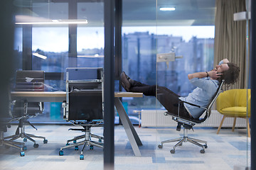 Image showing young businessman relaxing at the desk