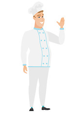 Image showing Young caucasian chef cook waving his hand.
