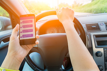 Image showing Driver keeps smartphone with correspondence