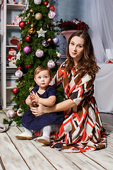 Image showing Little girl With her happy mother at studio with christmas decorations