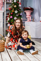 Image showing Little girl With her happy mother at studio with christmas decorations