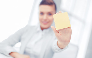 Image showing smiling businesswoman showing sticky note