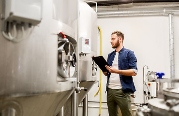 Image showing man with clipboard at craft brewery or beer plant