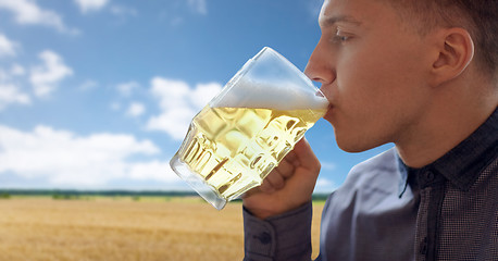 Image showing close up of young man drinking beer from glass mug