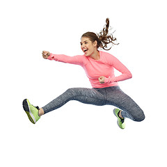 Image showing happy sporty young woman jumping in fighting pose