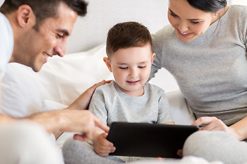 Image showing happy family with tablet pc in bed at home