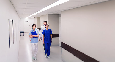 Image showing group of medics or doctors walking along hospital