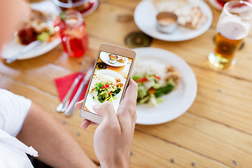 Image showing hand with smartphone picturing food at restaurant