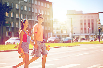 Image showing teenage couple with skateboards on city street