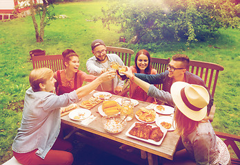 Image showing happy friends having dinner at summer garden party