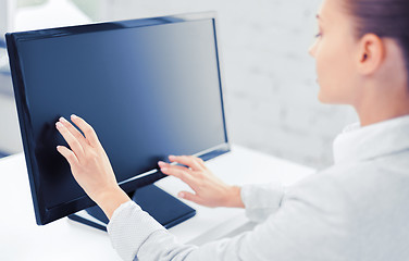 Image showing smiling businesswoman with touchscreen in office