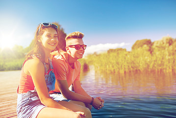 Image showing happy teenage couple sitting on river berth