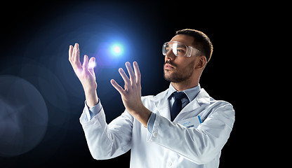 Image showing scientist in lab coat and goggles with light