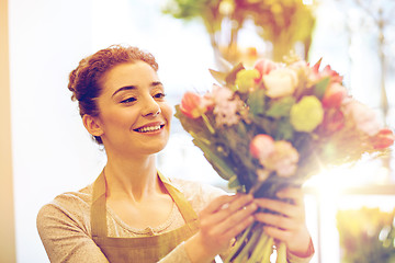 Image showing smiling florist woman making bunch at flower shop