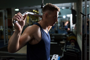 Image showing man flexing muscles on cable machine in gym